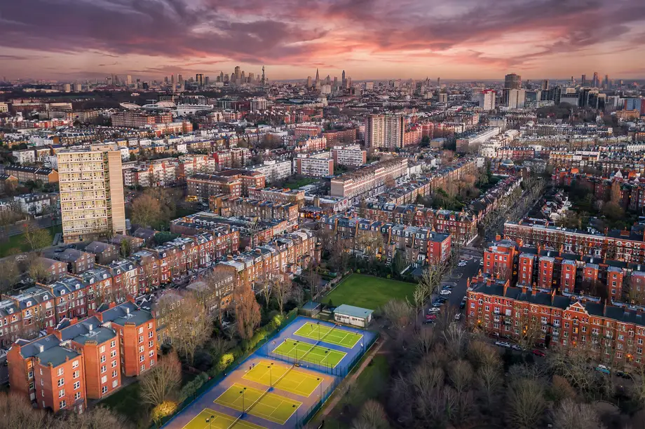 Aerial panorama at sunset over mansion blocks and tennis courts