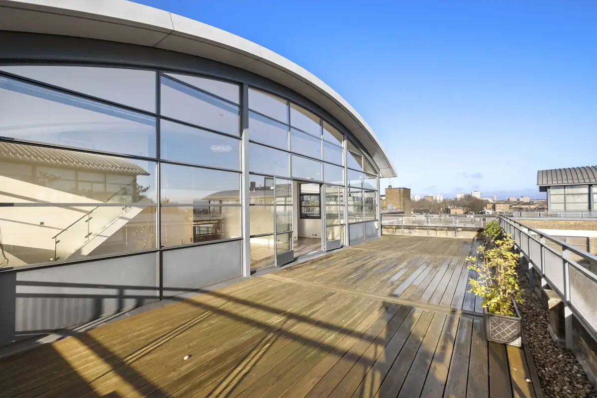 The same roof terrace styled with sofas, dining furniture and planting