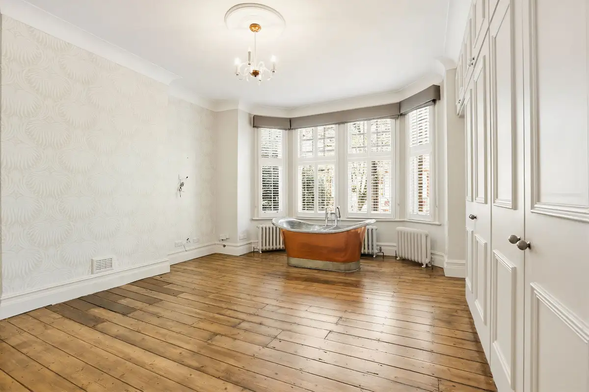 The same period bedroom virtually staged with a bed, chandelier and artwork