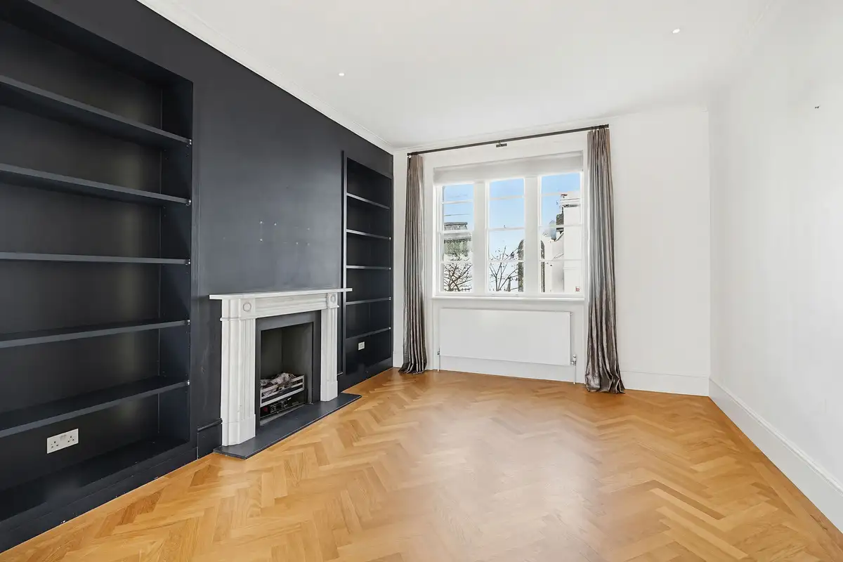 The same reception room virtually staged with sofas, a coffee table and styled shelves